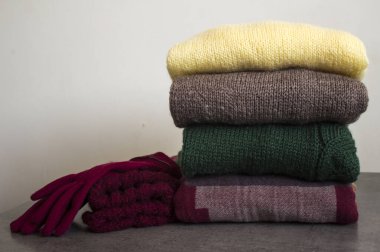 Temiz, yeni yıkanmış, düzgünce katlanmış kadın kışlıkları. Farklı türde kumaşlar. Boşluğu kopyala, kapat, üst görünüm.