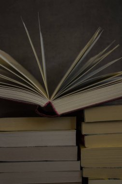 Koyu gri arka planda bir yığın eski kitap. Kitap sayfalarını aç. Kütüphane fotoğrafı. 