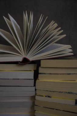 Koyu gri arka planda bir yığın eski kitap. Kitap sayfalarını aç. Kütüphane fotoğrafı. 