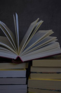 Koyu gri arka planda bir yığın eski kitap. Kitap sayfalarını aç. Kütüphane fotoğrafı. 