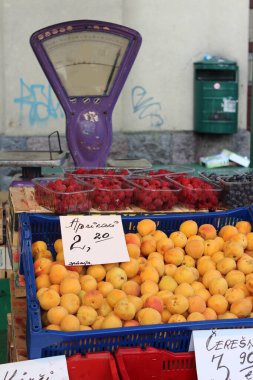 Riga 'daki yerel pazar. Fiyat etiketleri çevirisi: kayısı, kiraz. Taze meyve dükkanı.. 