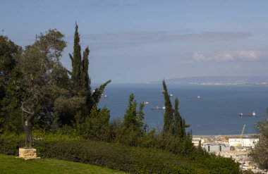 Yukarıdan güzel bir şehir manzarası. Meyveli portakal ağaçları, deniz manzarası, eski binalar, bulutlu mavi gökyüzü. İsrail 'de bahar. Orta Doğu 'nun Doğası. 
