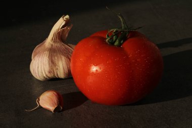 Koyu gri masada taze domates ve sarımsak.. 