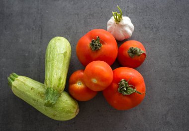 Masadaki makarna malzemeleri. Fotokopi alanı olan koyu gri arkaplanda taze sebzeler.. 
