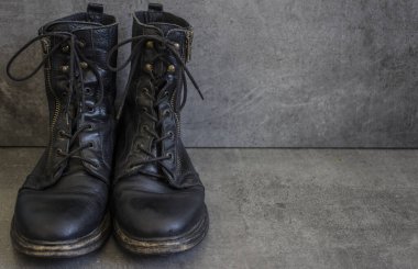 Bir çift siyah deri retro ayakkabı ve gri arka planda tahta ayakkabı fırçası.. 