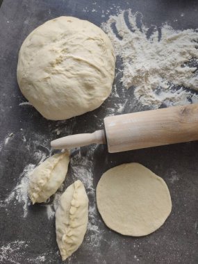 Hamur topu, makarna rulosu, koyu gri masada un. Bölgesel yemek fotoğrafı. Rus hamur işleri