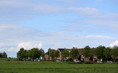 Güzel yaz manzarası. Bulutlu suluboya mavi gökyüzü, yeşil çimen tarlası. İdealist bir manzara. Sakin doğa arkaplanı.