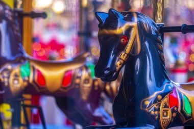 Parlak boyalı atlı karınca atları. Oldukça büyük boyalı yapay atlar, geleneksel süslemeler, dizginler, yeleler vs. Arka planda çeşitli dekoratif ögeler.