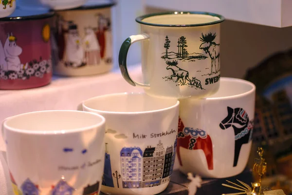 Stockholm ve İsveç ile ilgili resimlere sahip birkaç beyaz kupa (geyik, Dala atı). Hediye ya da hediyelik eşya dükkanı. Gösteriş. Popüler hediyelik eşyalar. Gezinizi hatırlamak için harika bir seçim. Sıcak renkler.