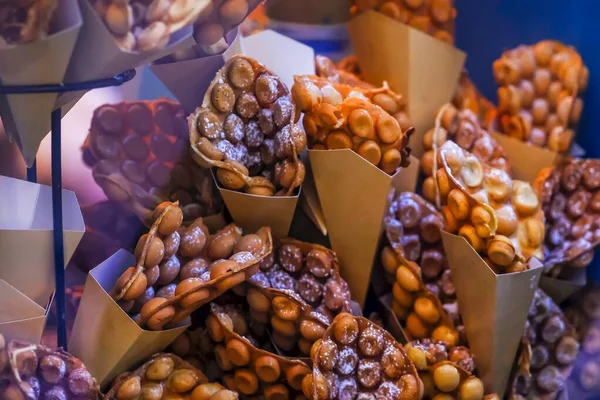 Hong Kong usulü waffle, yemek için yarım daire şeklinde katlanmış. Doldurulmuş büyük toplarla tanınabilir bir yüzeyi olan bir hamur işi. Sokakta genellikle sıcak yenir..