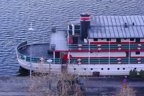 Deniz feribotu / yolcu gemisi, yolcuları sudan geçirmek ya da deniz tatili için kullanılıyor. Feribot toprak sete demirli. Bir sürü gemi parçası, ahşap deste, can yelekleri, yuvarlak pencereler gibi..