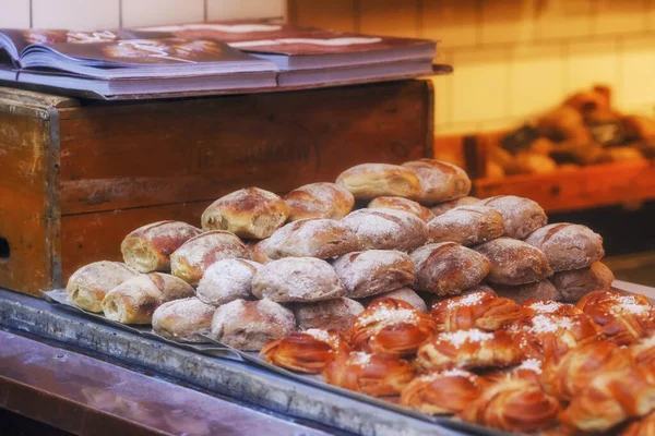Pastanede şeker tozuyla iştah açıcı taze çörekler. Taze, sıcak, lezzetli, çıtır çıtır çörekler. Ilık ışık ve renkler, keskinlik ve kompozisyon.