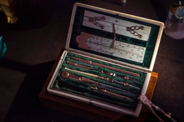 Zümrüt yeşili kadife bir çantadaki antika eşsiz çizim aletleri. Düzenli ölçüm ve çizim düzeni için kullanılır. Lüks hediye kutusu veya çanta, bir sürü metal araç, linea veya cetvel aracı. 