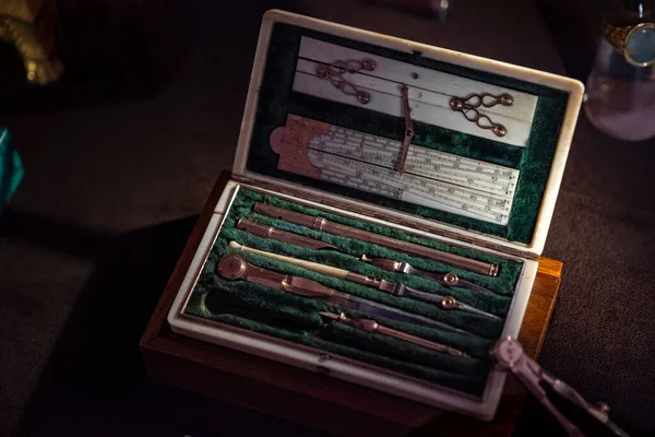 Zümrüt yeşili kadife bir çantadaki antika eşsiz çizim aletleri. Düzenli ölçüm ve çizim düzeni için kullanılır. Lüks hediye kutusu veya çanta, bir sürü metal araç, linea veya cetvel aracı. 