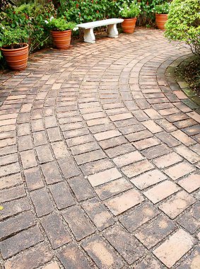 Bahçedeki geçit tuğla ve çakıllarla kaplı..