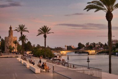 Guadalquivir nehrinden gün batımı, altın kule, tatilde olan insanlar, Seville, Endülüs, İspanya.