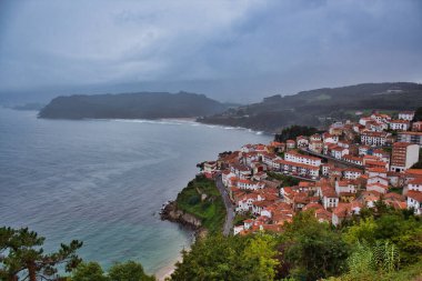 Bulutlu ve yağmurlu bir günde Lastres Kasabası