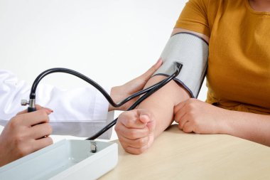 Doktorlar obez kadınların sağlıklarını kontrol etmek için basınç monitörleri kullanıyorlar. Ağır ağırlıklı hastalar için tedavi kavramı. Beyaz arkaplan