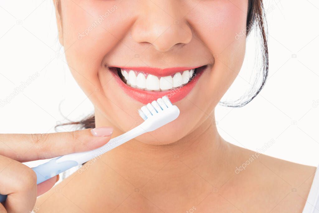 Beautiful smiling woman, clean white teeth, pink lips, hold a toothbrush. Oral care concept. White background