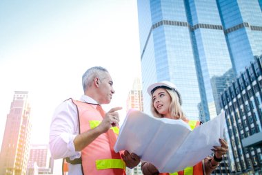 İnşaat mühendisleri ve genç mimarlar, çok ırklı bina tasarımcıları bir plan, araştırma ekibi toplantısı üzerinde birlikte çalışıyorlar. Kentsel kalkınma kavramları, kamu hizmetleri sistemlerinin modernizasyonu