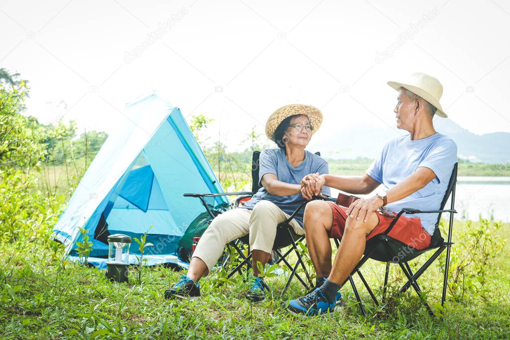 The elderly couple camping in the forest, happy to relax in retirement. Senior community concepts