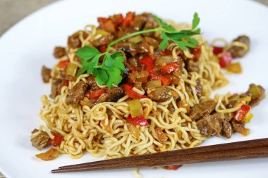 soğanlı biftek, biber ve Çin eriştesi.