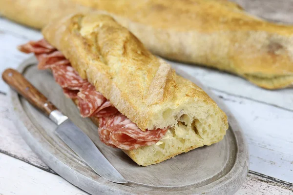 Dry sausage sandwich on a table — Stock Image Dry Sausage Sandwich Table Stock Image