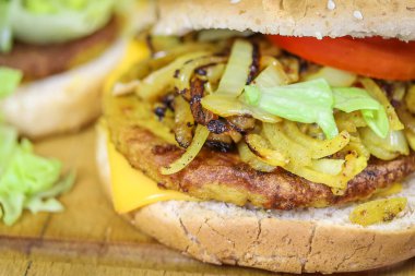 Tavuk, soğan, salata ve domatesli hamburger.