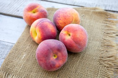 Çuval bezi ve ahşap arka planda şeftali