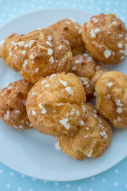 Tahta arka planda şeker incileri olan chouquette.