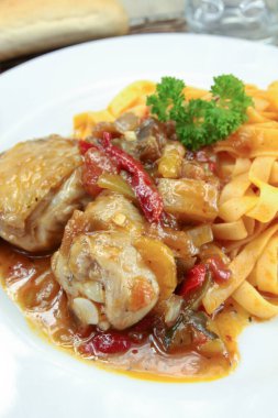 Biberli tavuk, soğan ve tabakta tagliatelle.