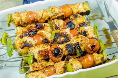 Bir tabakta ızgara tavuk şişi.