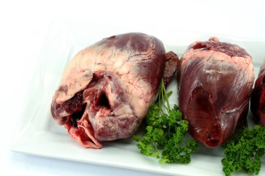 Beyaz arka planda çiğ domuz kalbi.