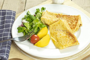 Peynirle doldurulmuş gözlemeler ve yanında yeşil salata.