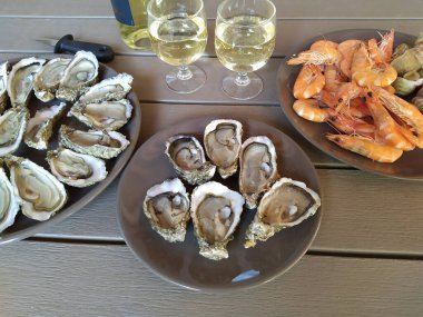 Bir bardak beyaz şarapla istiridye ve karides.