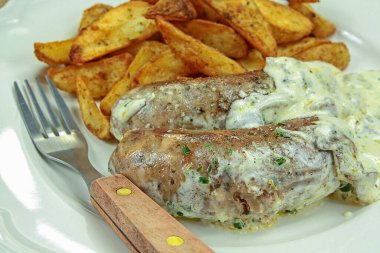 Kızarmış patatesle soslu andouillette.