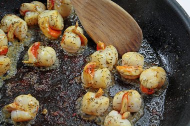 Tahta kaşıkla tavada istiridye.