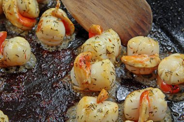 Tahta kaşıkla tavada istiridye.