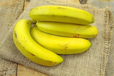 Çuval bezi ve ahşap arka planda muzlar