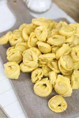 Kesme tahtasındaki çiğ tortellini
