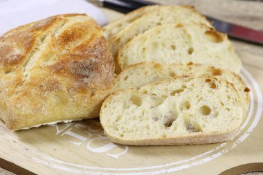 Bir somun dilimlenmiş ekmek masada.