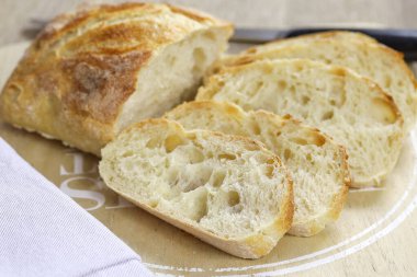 Bir somun dilimlenmiş ekmek masada.