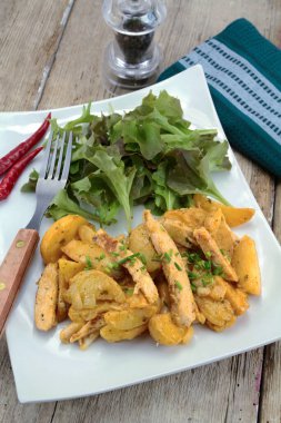 Tavada kızarmış patates ve salata.