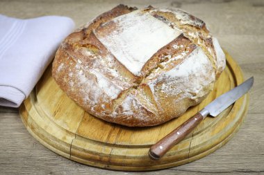 Kesme tahtasının üzerinde bir somun ekmek