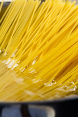 Sıcak suda çiğ spagetti.