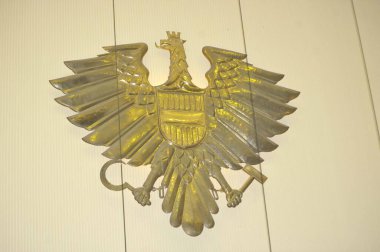 Avusturya Cumhuriyeti arması bir duvarda asılı.
