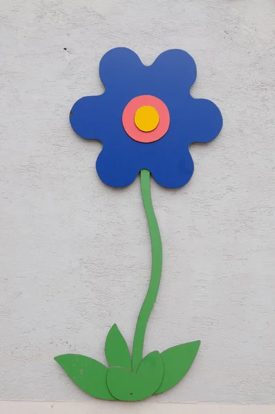 Голубой Цветочный Знак Зеленым Стеблем Установленным Стене — стоковое фото