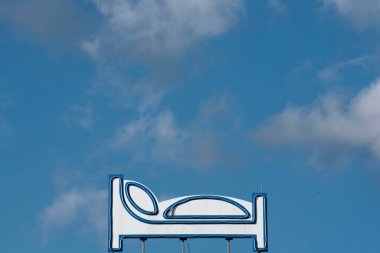 Mavi gökyüzü ve arkaplanda bulutlar olan yatak sembolü