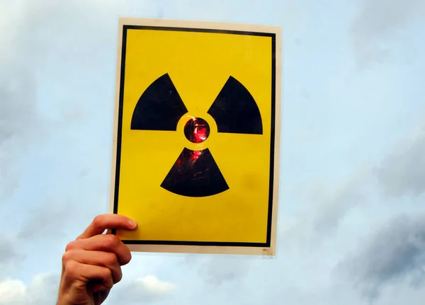 banner with yellow and black radioactive warning sign, cloudy sky