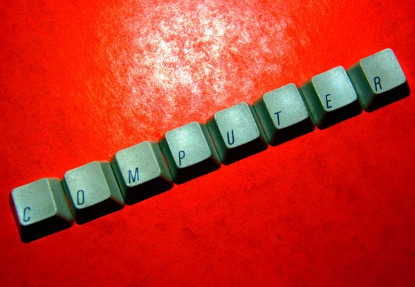 keyboard keys spelling the word computer on a red background